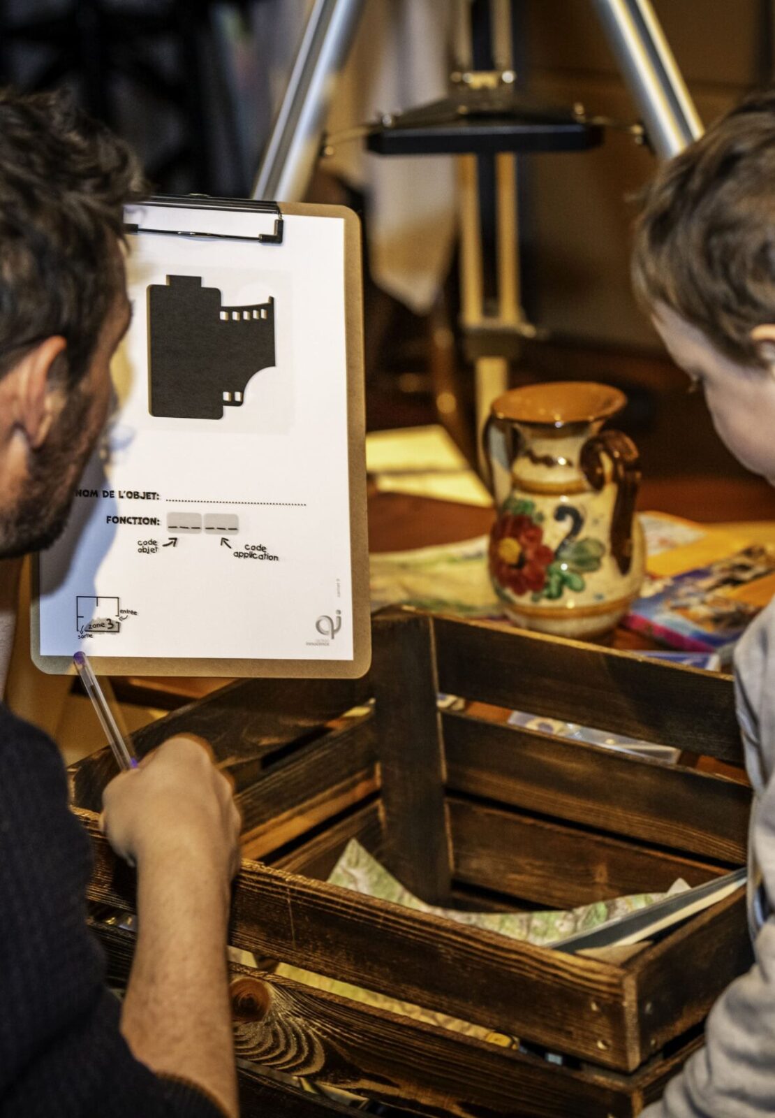 An adult guides a child through an interactive educational activity inside the Action Innocence traveling pavilion, encouraging learning and discussion around digital awareness using hands-on materials.