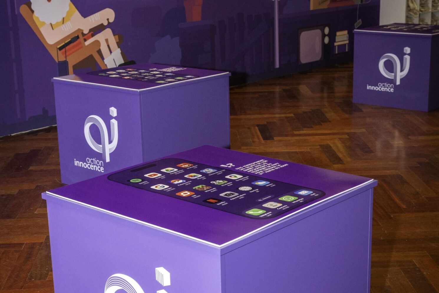 Interactive educational stations featuring Action Innocence–branded cubes with touchscreen-style graphics, inviting visitors to engage with digital safety themes through playful, game-like interfaces as part of the Action Innocence – Traveling educational pavilion.