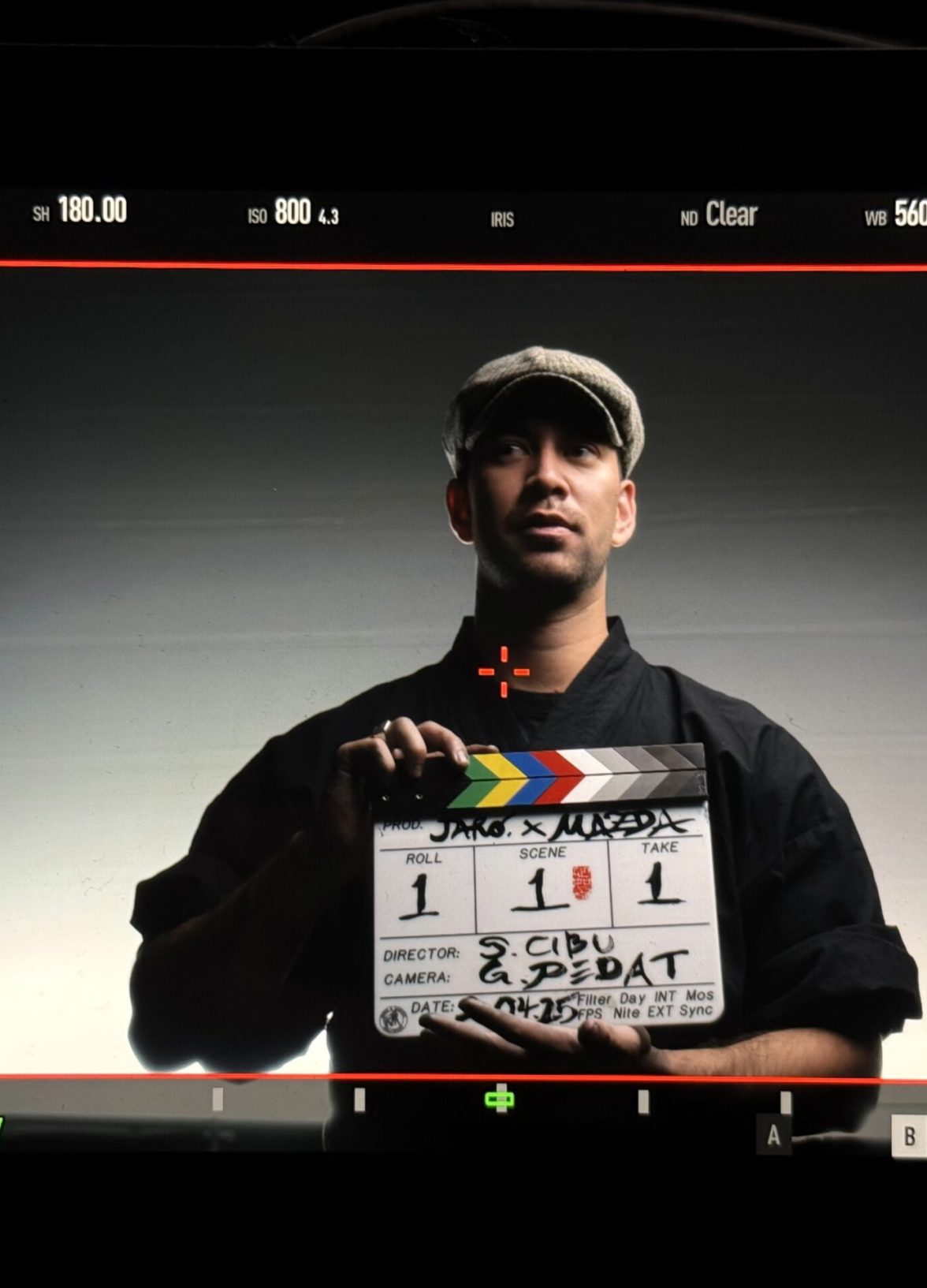 Artist holding a film clapperboard framed through a camera monitor during the Mazda – Cinematic reveal of the Mazda 6E.