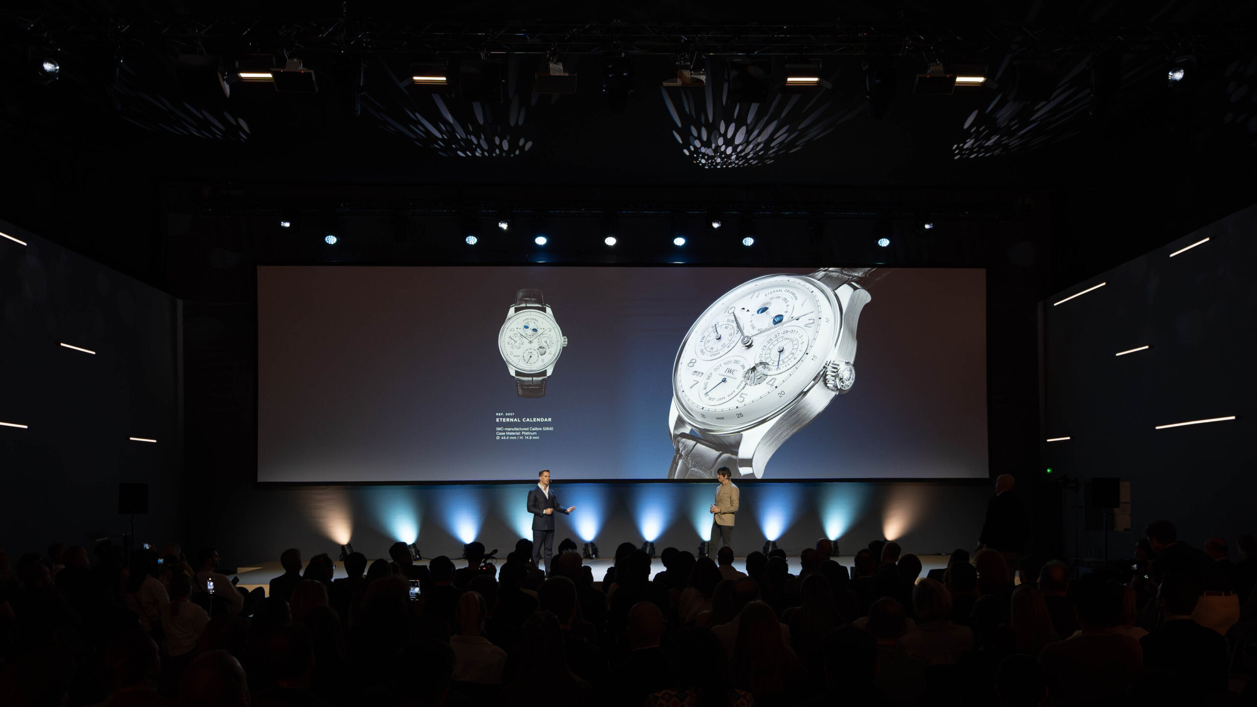 Product presentation on stage featuring a luxury watch displayed on a large screen during Watches & Wonders – Geneva International Watchmaking Exhibition.
