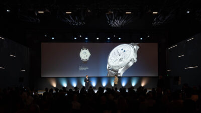 Product presentation on stage featuring a luxury watch displayed on a large screen during Watches & Wonders – Geneva International Watchmaking Exhibition.