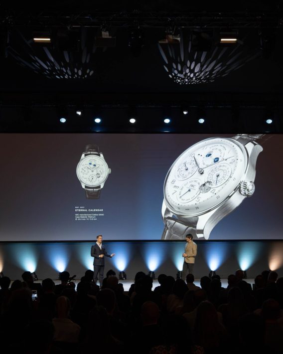 Product presentation on stage featuring a luxury watch displayed on a large screen during Watches & Wonders – Geneva International Watchmaking Exhibition.