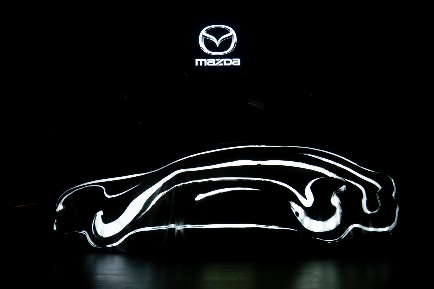 Abstract light outline forming the silhouette of a car beneath the Mazda logo during the Mazda – Cinematic reveal of the Mazda 6E.