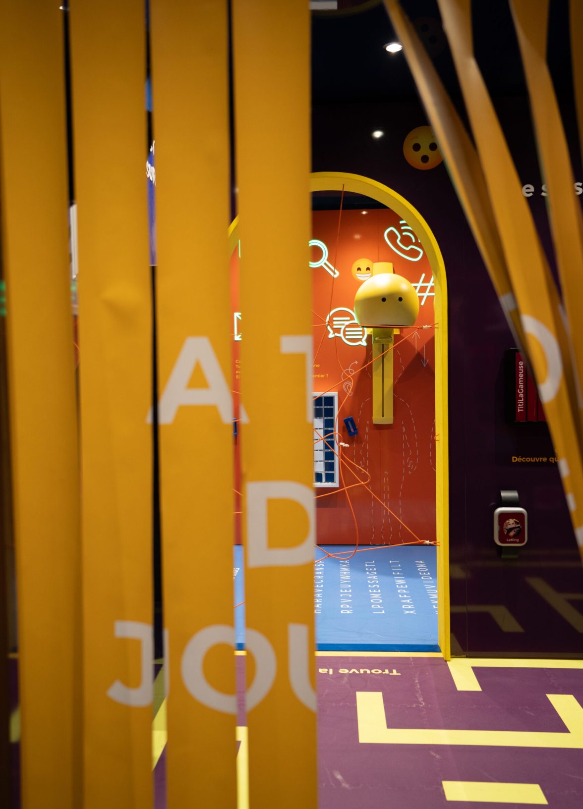 Entrance to an immersive space framed by flexible curtain elements and playful scenography, immediately drawing visitors into a visually engaging environment.