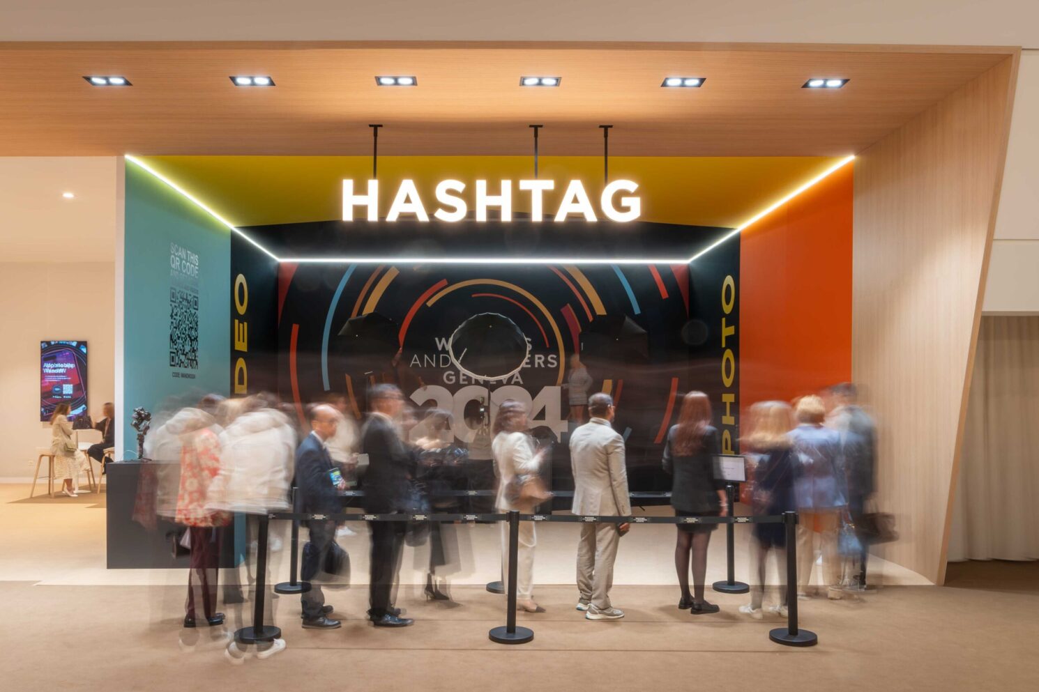 Visitors queueing in front of the “Hashtag” interactive space with motion blur, during Watches & Wonders – Geneva International Watchmaking Exhibition.