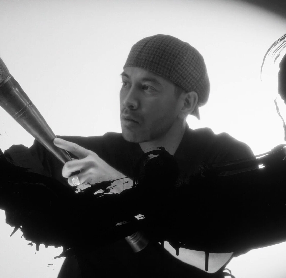 Artist performing a cinematic brushstroke gesture in black ink during the Mazda – Cinematic reveal of the Mazda 6E.